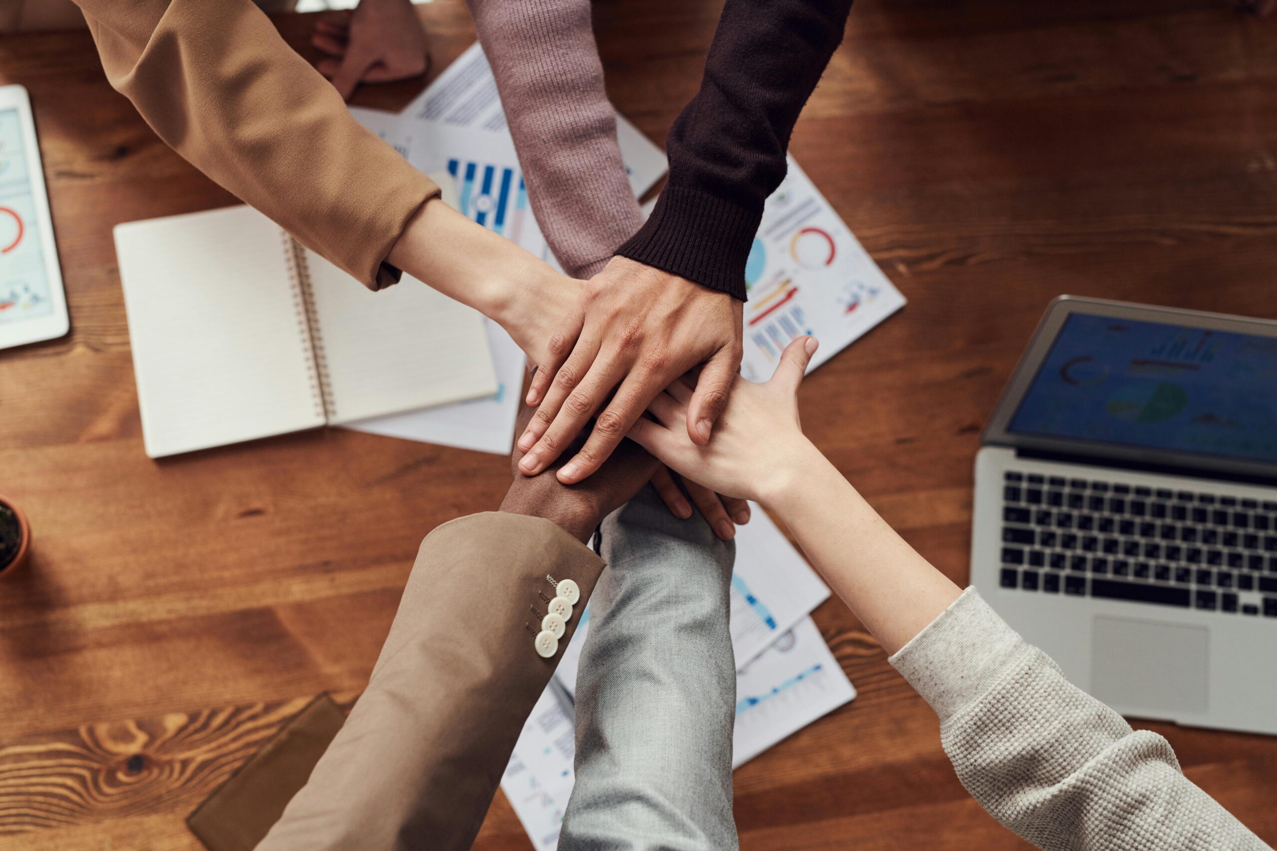 A team of people putting their hands together in an office setting